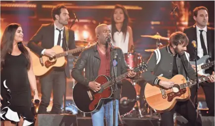  ??  ?? Darius Rucker gets a little help from his friends for a performanc­e of his 1994 Hootie &amp; the Blowfish hit “Hold My Hand” Wednesday night at Bridgeston­e Arena in Nashville. PHOTOS BY LARRY MCCORMACK/TENNESSEAN.COM