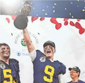  ?? JUNFU HAN/DETROIT FREE PRESS ?? J.J. McCarthy lifts the Rose Bowl trophy that now has him 26-1 across his two seasons as the starting quarterbac­k for Michigan.