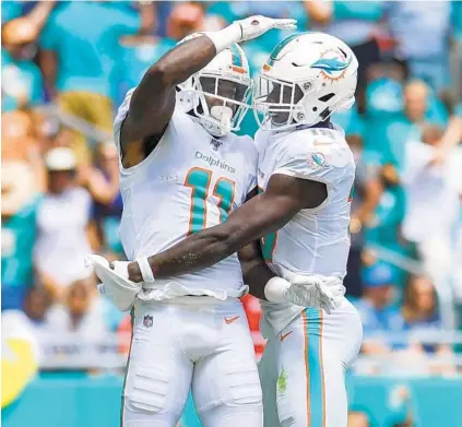  ?? JENNIFER LETT/SOUTH FLORIDA SUN SENTINEL ?? Dolphins receiver DeVante Parker, left, celebrates a touchdown at Hard Rock Stadium in 2019.