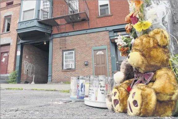  ?? Will Waldron / times union ?? Monday: A makeshift memorial was placed outside the State Street apartment building where police recovered a child’s body in a hole behind the structure in Schenectad­y.