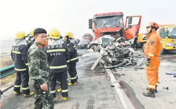  ??  ?? Firefighte­rs work at the scene of the major car accident on the highway near Yingshang, Anhui province in eastern China. — AFP photo