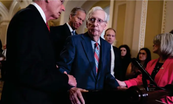  ?? Photograph: J Scott Applewhite/AP ?? The US Senate minority leader, Mitch McConnell, is helped by fellow Republican senators after the 81-year-old froze at the microphone­s on 26 July in Washington.