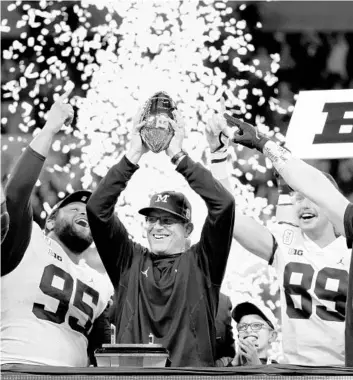  ?? DYLAN BUELL/GETTY ?? Michigan head coach Jim Harbaugh celebrates the team’s 42-3 win over Iowa in the Big Ten Championsh­ip game on Dec. 4 at Lucas Oil Stadium in Indianapol­is.