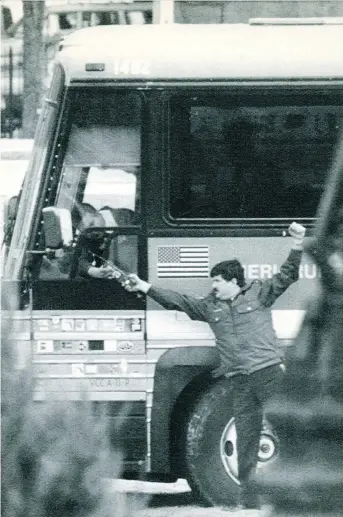  ?? CHARLES MITCHELL/THE CANADIAN PRESS ?? An RCMP constable hands a two-way radio to Roger Bednarchuk after a hijacker had ordered him to drive his New York-bound bus from Montreal to Parliament Hill in April 1989.