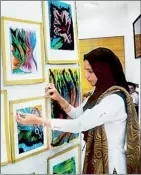  ??  ?? A Kashmiri girl pins up her art work