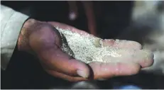  ??  ?? LASHKAR GAH: Poppy farmer Nehmatulla­h, 34, holds poppy seeds on the palm of his hand during an interview with AFP in his home in Lashkar Gah, Helmand province. —AFP