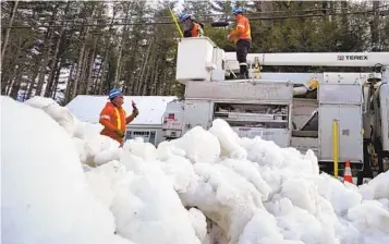  ?? CHARLES KRUPA AP ?? Linemen from Canada work to restore power to a neighborho­od in Windham, N.H. on Wednesday.