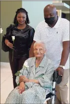  ?? Sue Ogrocki / Associated Press ?? Viola Fletcher, center, the oldest living survivor of the Tulsa race massacre, holds a rose she received as she arrives for a luncheon honoring survivors Saturday in Tulsa, Okla.