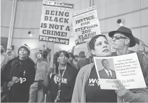  ?? — Gambar AFP ?? TUNTUT KEADILAN: Penunjuk perasaan memegang gambar Clark semasa protes Black Lives Matter di luar Dewan Bandar raya Sacramento di Sacramento, California kelmarin.