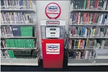  ?? DAN JANISSE ?? An old gas pump sits between the shelves of the Windsor Public Library’s new Chisholm branch, which officially opened on Saturday.