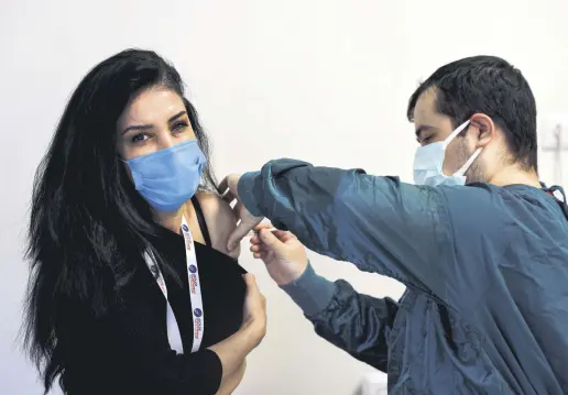  ??  ?? A woman receives a shot of the Pfizer-BioNTech vaccine at a hospital in Istanbul, Turkey, April 9, 2021.