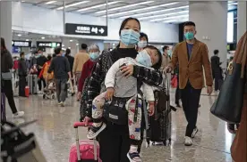  ?? KIN CHEUNG / ASSOCIATED PRESS ?? Passengers wearing protective face masks enter the departure hall of a high-speed train station in Hong Kong on Thursday. China closed off a city of more than 11 million people, halting transporta­tion and warning against public gatherings, to try to stop the spread of a deadly new virus that has sickened hundreds.