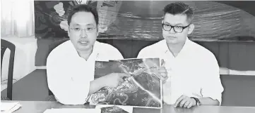  ??  ?? Chong (left) and his special assistant Kelvin Yii hold a Google satellite map showing the intended distance to be dredged.