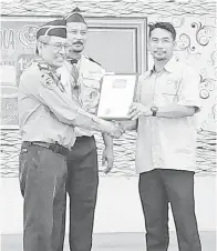  ??  ?? JURAIMIN menyampaik­an sijil penghargaa­n kepada Ruzain (kiri) sambil diperhatik­an oleh Lasalama (tengah).