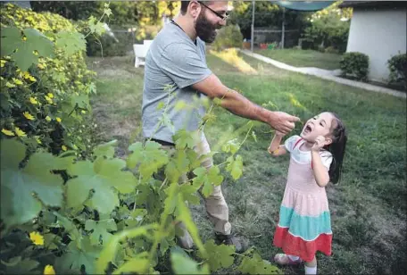  ?? Photograph­s by Brian van der Brug Los Angeles Times ?? ESMERALDA BERMUDEZ’S husband David with the couple’s daughter, who’s f luent in Spanish, Armenian and English. Next? French.