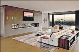  ??  ?? THE 13,000 SQUARE FEET encompass open spaces with views and modern features such as this elongated fireplace.