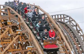  ?? AP STEPHEN M. DOWELL/ ORLANDO SENTINEL VIA AP ?? ABOVE: People ride a roller coaster Saturday at Lagoon amusement park in Farmington, Utah.
LEFT: Cocoa Beach, Fla., is packed with beachgoers on Saturday.