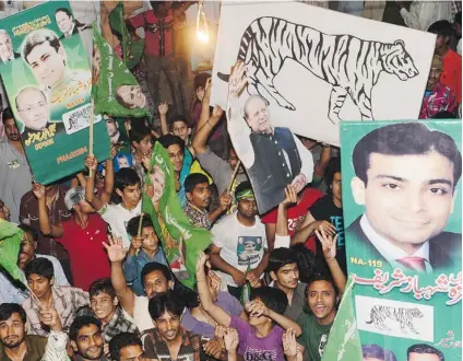  ?? ARIF ALI/ AFP/ GETTY IMAGES ?? Supporters of former Pakistani Prime Minister Nawaz Sharif celebrate the victory of their party Sunday.