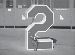  ?? MARCIO JOSE SANCHEZ/AP ?? Flowers are placed in front of Tommy Lasorda’s retired No. 2 on Friday at Dodger Stadium in Los Angeles. Lasorda died Thursday night.