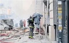  ?? AFP ?? A woman is evacuated by firefighte­rs after the explosion of a bakery on Rue de Trevise in central Paris on Saturday.