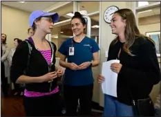  ?? ?? From left: Physical therapist Missy Darnell and occupation­al therapist Sarah Bury talk with Briar, who will graduate on time next month and plans to live in the San Francisco area close to her parents.