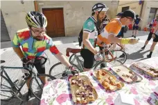  ?? — AFP ?? Vintage bicycle’s enthusiast­s eat at a refuelling area during the ‘Eroica Montalcino’ festive event on Sunday near Montalcino.