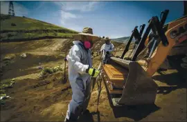  ?? THE ASSOCIATED PRESS ?? Workers wearing full protection gear as a precaution against the new coronaviru­s unload a coffin in Tijuana, Mexico, on May 5 that contained the remains of a person who died from the virus. An area of the municipal cemetery has been set apart for COVID-19 victims.