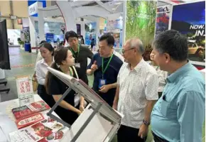  ?? ?? LOTS TO LEARN: Chairman of VITA Vũ Thế Bình (second from the right) visits Gumi's booth at the VITM.