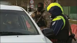  ?? RU-RTR RUSSIAN TELEVISION ?? In this image taken from footage provided on Friday, a Russian policeman checks documents of drivers not far from the border between Russia and Ukraine in Russia. Russia has declared that a group of saboteurs from Ukraine crossed into its territory and attacked border villages, a raid marking an escalation of the war that dragged into a second year.