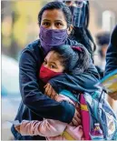  ??  ?? Jazmin Martinez hugs her kindergart­ner daughter, Jazmin Lorenzo, while dropping her off at John Robert Lewis Elementary School on Tuesday.