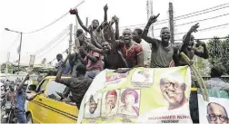  ?? PEIPIUS UTOMI EKPEI / AFP / Gett y Images ?? Supporters of Muhammadu Buhari sit on top of a van as they celebrate their candidate’s victory in Lagos Wednesday.