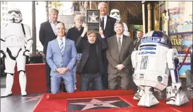  ?? Alberto E. Rodriguez/Getty Images for Disney ?? Actor Mark Hamill, center, celebrates his star on the Hollywood Walk of Fame Thursday flanked by Harrison Ford, left rear, filmmaker George Lucas, second from left rear, and Los Angeles and Chamber of Commerce officials.