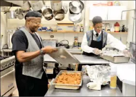  ?? Staff Photo by John Rawlston ?? Roy Newton, left, and Demetrius Goins work in the kitchen of the Bistro @ the Beth, an all-you-care-to-eat restaurant open to the public in the Bethlehem Community Center.