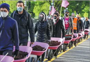  ?? EVELYN HOCKSTEIN / REUTERS ?? Members of environmen­tal group Extinction Rebellion bring cow manure to dump outside the White House on Thursday, in an Earth Day protest against US President Joe Biden’s climate plan.