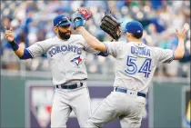  ?? Associated Press photo ?? Toronto Blue Jays' Jose Bautista, left, and pitcher Roberto Osuna, right, celebrate at the end of a baseball game against the Kansas City Royals at Kauffman Stadium in Kansas City, Mo., Sunday.