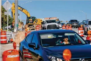  ?? GREG LOVETT / THE PALM BEACH POST ?? Motorists navigate constructi­on barriers last month on Woolbright Road heading east from Interstate 95 in Boynton Beach. Completion of the road work has been delayed.