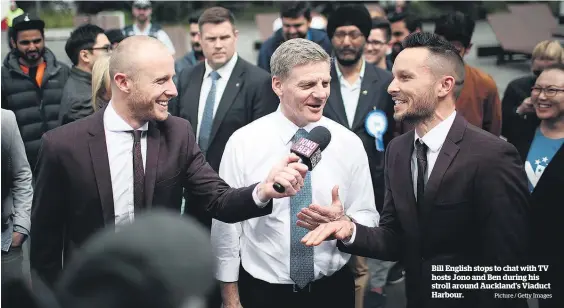  ?? Picture / Getty Images ?? Bill English stops to chat with TV hosts Jono and Ben during his stroll around Auckland’s Viaduct Harbour.