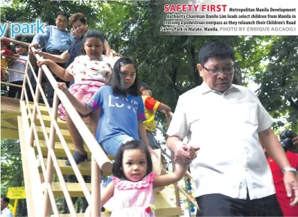  ?? JOSHUA VERA CRUZ ?? Metropolit­an Manila Developmen­t Authority Chairman Danilo Lim leads select children from Manila in crossing a pedestrian overpass as they relaunch their Children’s Road Safety Park in Malate, Manila.