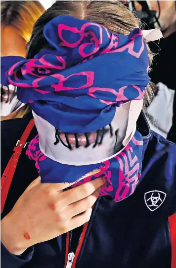  ??  ?? The British teenager convicted of lying about being gang-raped covers her face as she leaves Famagusta court in Paralimni, Cyprus. Along with around 25 supporters, she was wearing a mask with an image of stitched-up lips in protest at the judgment