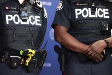  ?? ANDREW FRANCIS WALLACE/TORONTO STAR FILE PHOTO ?? Toronto police officers display a Taser and camera during a press conference introducin­g new body-worn police video cameras in 2015. “Some police will simply decide not to turn on their cameras at all," writes Desmond Cole.