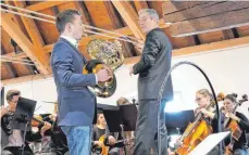  ?? FOTO: GÜNTER VOGEL ?? Hornsolist Thomas Bierfeld (l.) eröffnete das Konzert des Universitä­tsorcheste­rs unter der Leitung von Burkhard Wolf (r.).