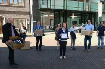  ?? FOTO JAN AUMAN ?? De directeurs van onder meer Sint-Eduardus, Sint-Cordula, De Tuimelaar, Heilige Familie en GO!-basisschoo­l Vijverhof kwamen de laptops in ontvangst nemen bij schepen Iefke Hendrickx (N-VA) centraal in De Kaekelaar.