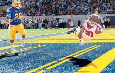  ?? Photograph­s by Wally Skalij Los Angeles Times ?? DEONTAY BURNETT MADE a diving catch for a touchdown against Texas last week, but he couldn’t come up with this one in the fourth quarter against Cal after beating safety Quentin Tartabull. Burnett did have nine catches for 76 yards and a score.