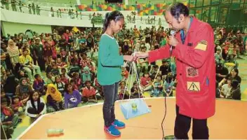  ??  ?? NELLY Shafika mencuba eksperimen sains pada lawatan ke Pusat Sains Negara.