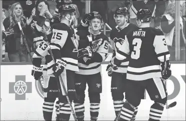  ?? MATT KINCAID / GETTY IMAGES / AFP ?? Pittsburgh Penguins’ Jake Guentzel (center) is congratula­ted by teammates after scoring against the Ottawa Senators in Pittsburgh last week. The Penguins launch their defense of the Stanley Cup in Wednesday’s opening game of a best-of-seven...