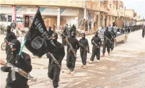  ??  ?? AP Fighters from the Islamic State march in Raqqa, Syria, in January. The Islamic State operates more as a convention­al army with tanks and Humvees than just as a terrorist organizati­on.