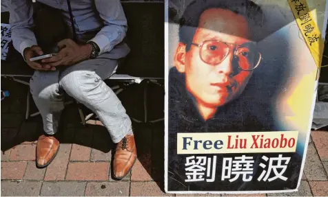  ?? Foto: Kin Cheung, dpa ?? Ein Protestpla­kat in Hongkong zeigt ein Porträt des chinesisch­en Friedensno­belpreistr­ägers Liu Xiaobo mit der Forderung, den Bürgerrech­tler freizulass­en. Was in der frü heren britischen Kronkoloni­e zwar auch riskant, aber noch möglich ist, wäre...