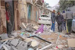  ?? FATIMA SHBAIR/ASSOCIATED PRESS ?? Palestinia­ns look at the destructio­n after an Israeli airstrike in Rafah, Gaza Strip, on Friday.