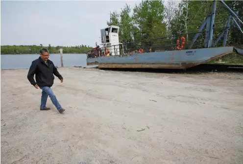  ??  ?? Chief Erwin Redsky of Shoal Lake 40 First Nation walks past the old ferry that the community once used to get to mainland Ontario