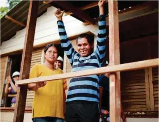  ?? PHOTO CREDIT: HANIS ABD RAZAK ?? More than 12,000 Orang Asli are in need of proper housing aid. One of the Orang Asli families celebratin­g moving in to their new home.